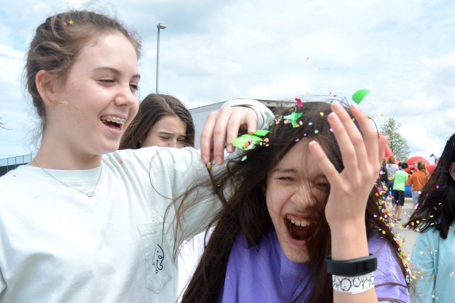 Seventh grader Brooke G. smashes a confetti egg on seventh grader Nya Ms head.